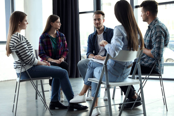 Psychotherapist working with patients in group therapy session indoors - Foto, afbeelding