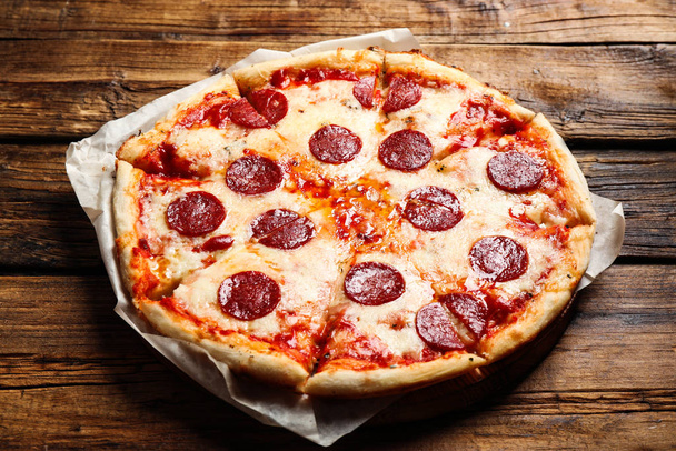 Гаряча смачна піца пепероні на дерев'яному столі
 - Фото, зображення