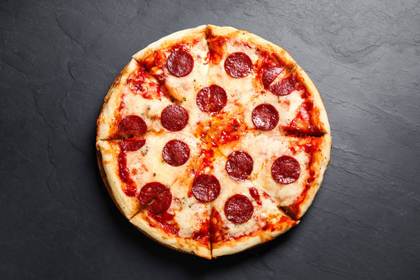 Hot delicious pepperoni pizza on dark table, top view - Foto, afbeelding