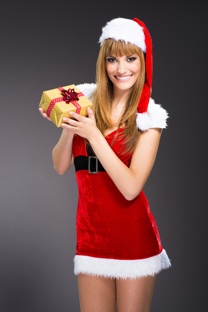 Portrait of young, sexy woman Santa with gift boxes - 写真・画像