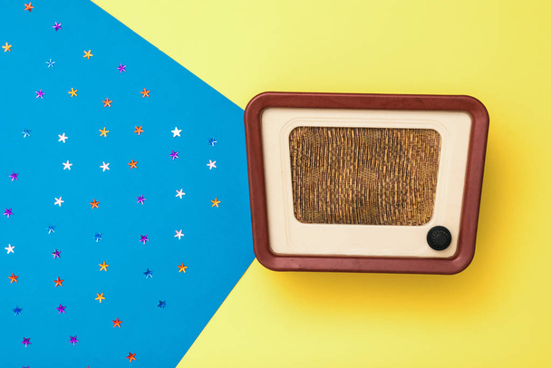 Vintage radio on a yellow and blue background with stars. Simulation of radio broadcasts. - Photo, Image