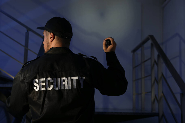 Karanlıkta merdivenlerden çıkan el fenerli bir erkek güvenlik görevlisi. - Fotoğraf, Görsel