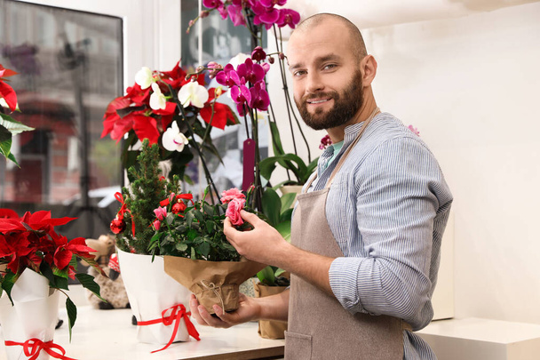 Professional male florist in apron at workplace - Fotó, kép