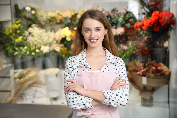 Professional female florist in apron at workplace - Valokuva, kuva