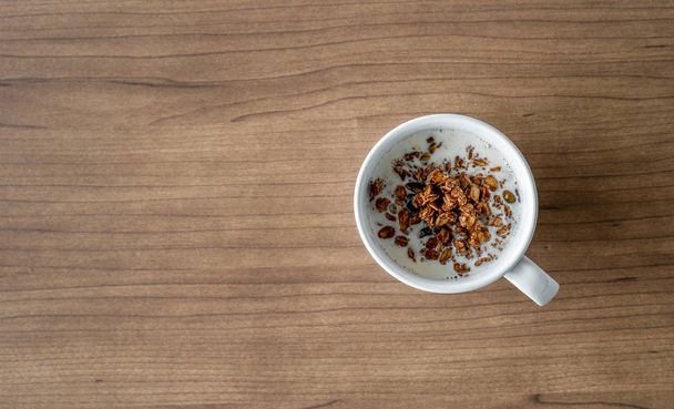 σπιτική γκρανόλα με γάλα για πρωινό σε ξύλινο τραπέζι. πάνω όψη - Φωτογραφία, εικόνα