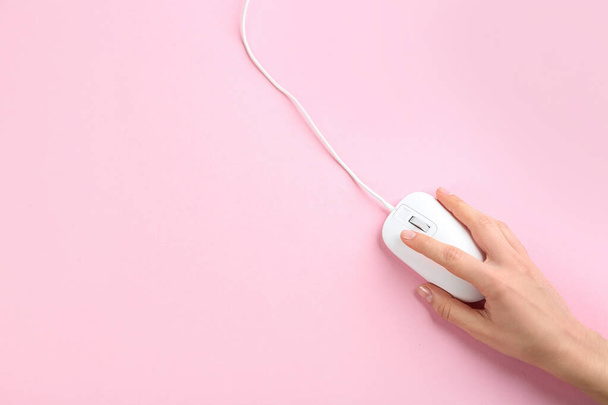 Woman using modern wired optical mouse on pink background, top view. Space for text - Foto, Imagem