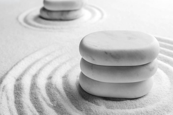 Stack of white stones on sand with pattern, space for text. Zen, meditation, harmony - Zdjęcie, obraz