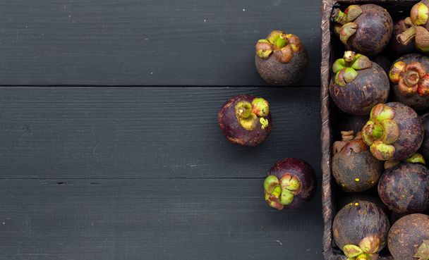 closeup mangosteen fruit on black wood table. top view - Valokuva, kuva