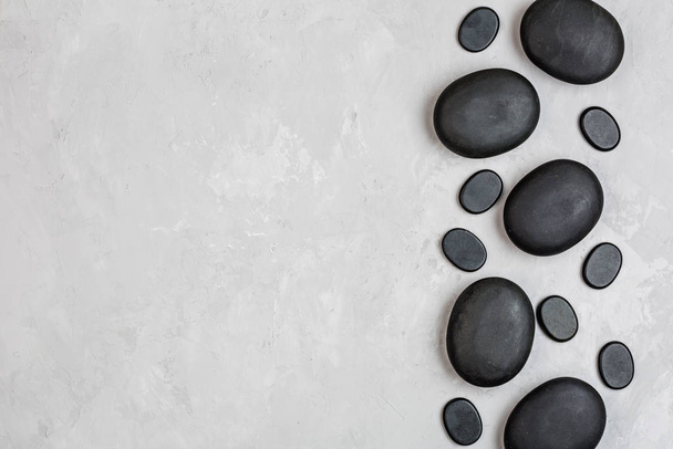 Top view of hot spa stones set for massage treatment on gray concrete background with copy space. Elegant and luxury spa. Flat lay, overhead, mock up, template. Health and beauty care concept - Foto, Bild