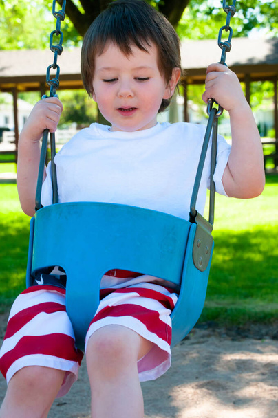 Ένα μικρό αγόρι απολαμβάνει τη μέρα του στο πάρκο της πόλης - Φωτογραφία, εικόνα