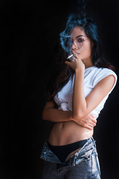 πορτρέτο ελκυστική νεαρή γυναίκα καπνίζει ένα τσιγάρο στο δωμάτιο.  - Φωτογραφία, εικόνα