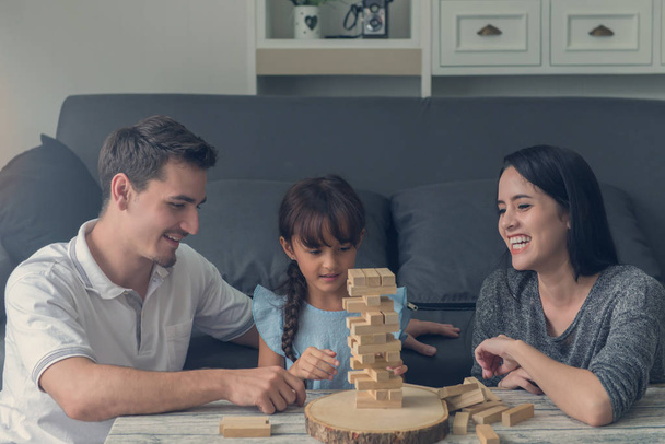 happy family and Daughter playing the wooden blocks tower at hom - Photo, Image
