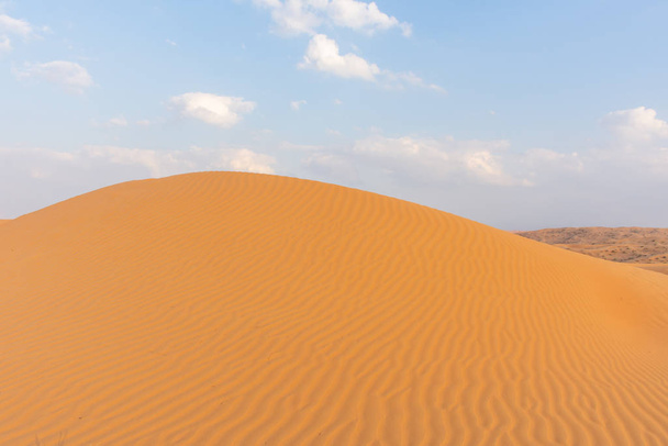 Naplemente a sivatagban egy texturált és mintázott gerincen keresztül, látványos változó alakzatokat hozva létre. Egyesült Arab Emírségek. Sivatagi koncepció. - Fotó, kép