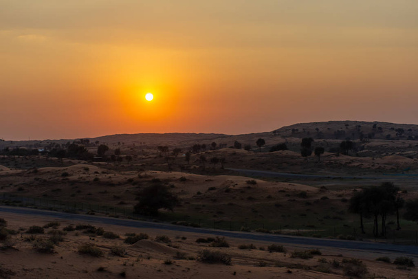 Dubai yakınlarındaki Birleşik Arap Emirlikleri 'nde, Ras al Khaimah' da kum tepeleri üzerinde turuncu çöl günbatımı. Lüks Seyahat. - Fotoğraf, Görsel