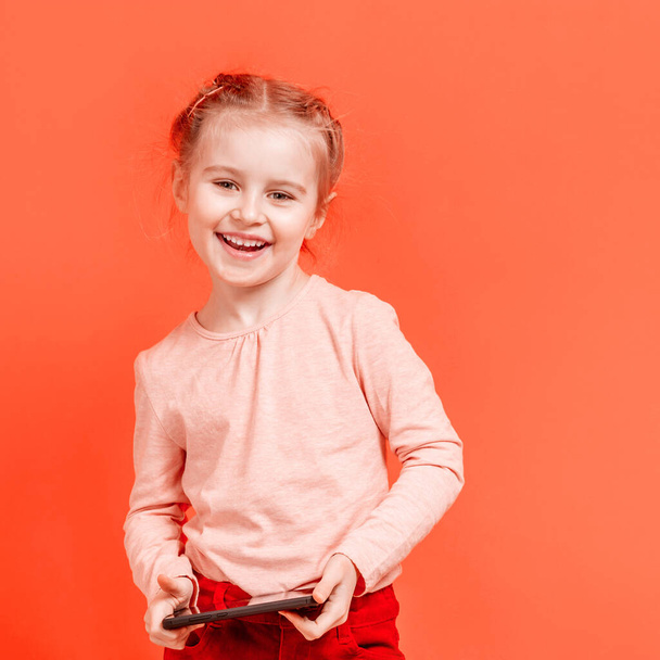 Smiling girl kid holding mobile phone - 写真・画像