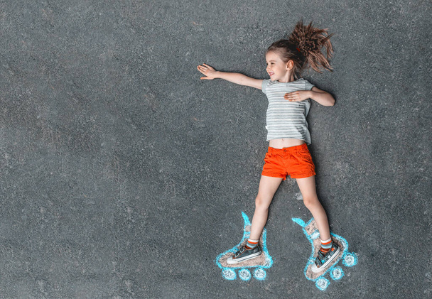 Sweet girl in roller skates painted with chalk - Foto, immagini