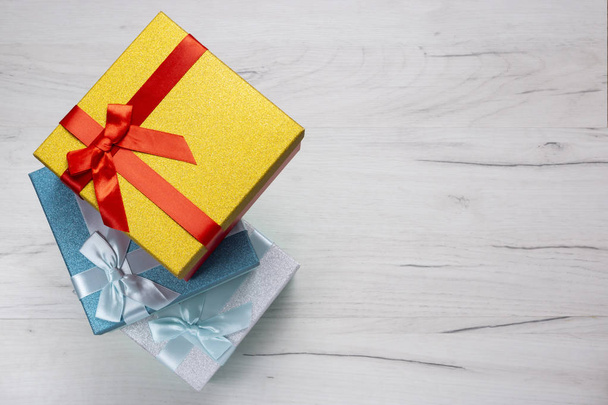 Φωτεινές διακοπές πολύχρωμα κουτιά δώρων με μια κορδέλα δώρο και τόξα - Φωτογραφία, εικόνα