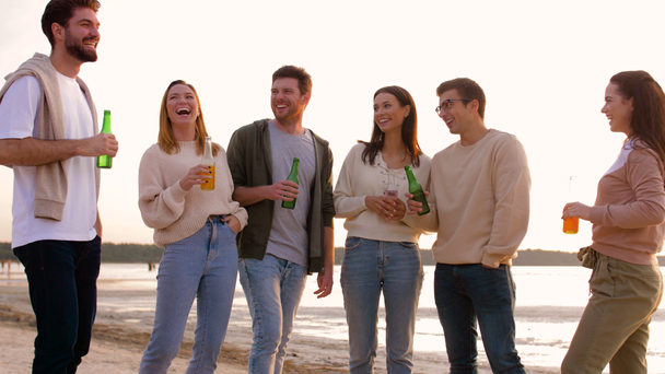 przyjaciół z napojami bezalkoholowymi rozmawiając na plaży - Materiał filmowy, wideo