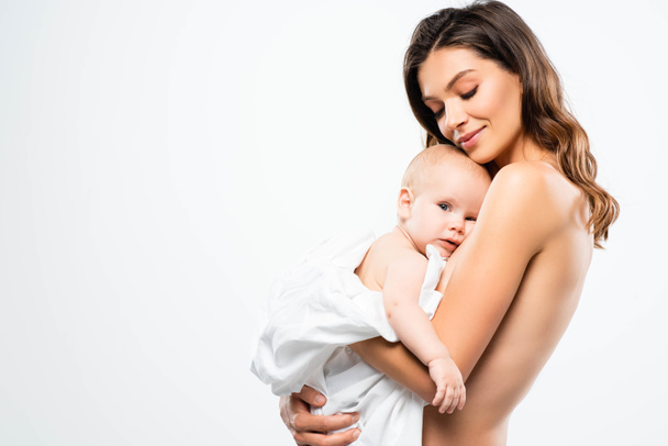 portrait of smiling naked mother hugging baby, isolated on white - Фото, зображення