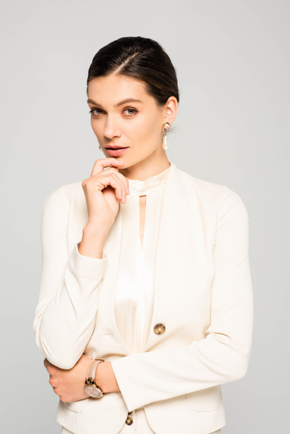 elegant thoughtful businesswoman in white suit, isolated on grey - Zdjęcie, obraz