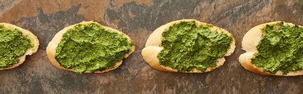 flat lay with baguette slices with delicious pesto sauce on stone surface, panoramic shot - Foto, Bild