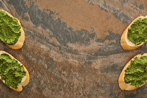 vista superior de fatias de baguete com delicioso molho pesto na superfície de pedra
 - Foto, Imagem