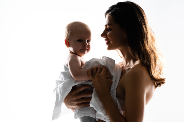 silhouette of smiling mother holding baby boy on hands, isolated on white - Photo, Image