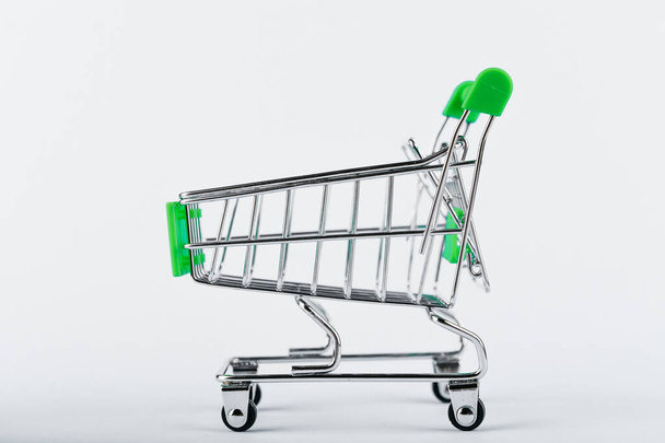 Shopping trolley on a white background. Green color. Place for an inscription. Shopping concept. - Fotografie, Obrázek