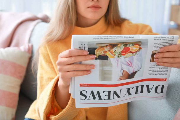 Giovane donna che legge il giornale a casa - Foto, immagini