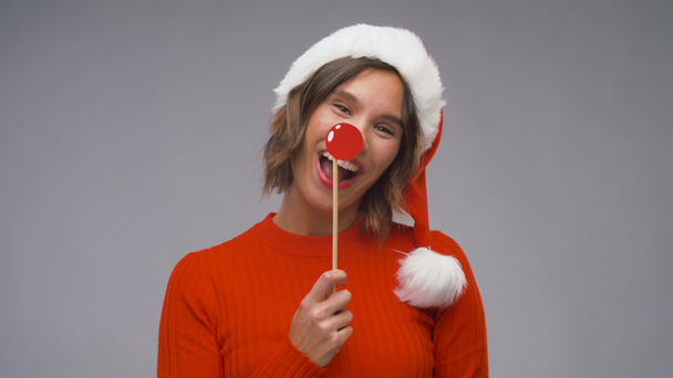 サンタヘルパーの帽子の女性はクリスマスを楽しんでいます - 映像、動画