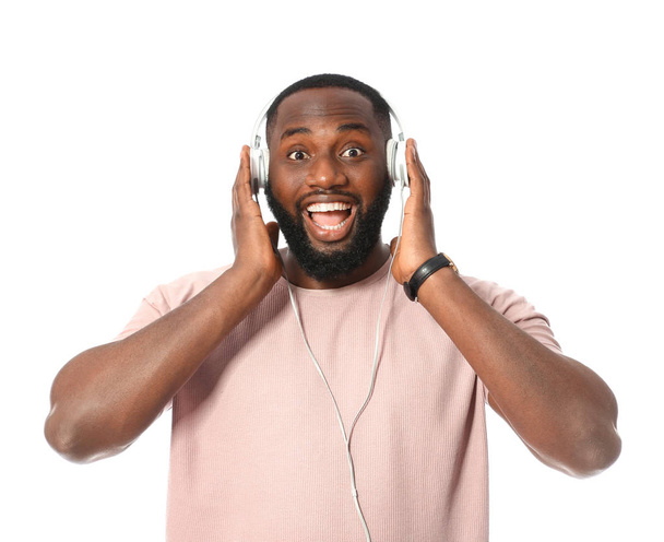 Emotional African-American man listening to music on white background - Foto, Imagem