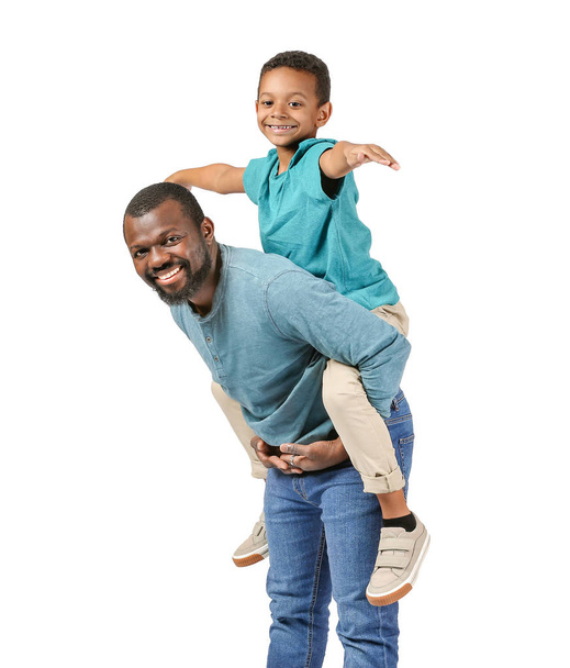 Portrait of African-American man with his little son on light background - Photo, Image