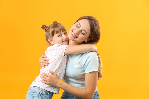 Portrait of happy mother and daughter on color background - Photo, Image