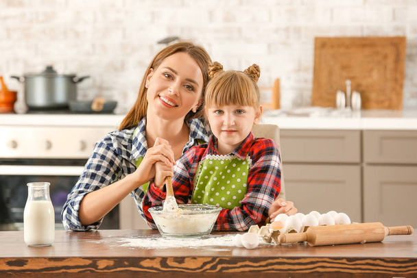 Boldog anya és lánya süteményt főz otthon - Fotó, kép