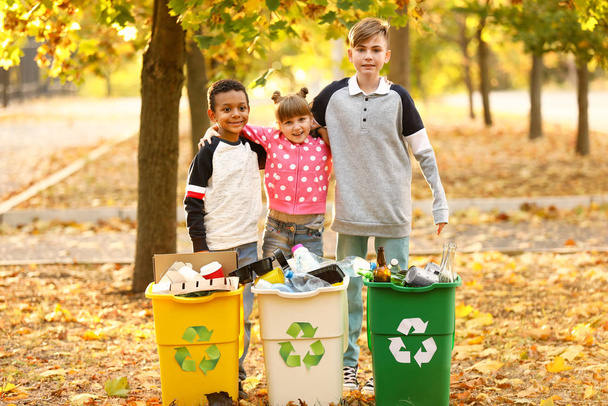 Małe dzieci zbierające śmieci na zewnątrz. Pojęcie recyklingu - Zdjęcie, obraz
