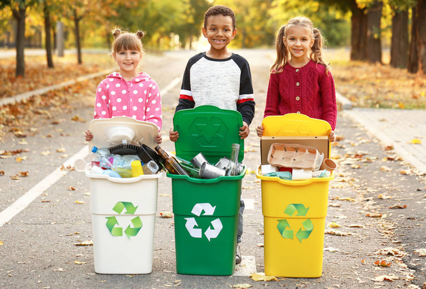 Piccoli bambini che raccolgono spazzatura all'aperto. Concetto di riciclaggio
 - Foto, immagini