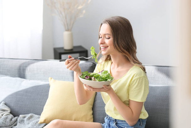 Mulher comendo salada de legumes saudável em casa
 - Foto, Imagem