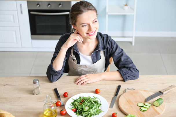 Donna con gustosa insalata di verdure in cucina
 - Foto, immagini
