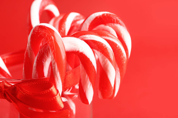 色の背景にクリスマスキャンディ缶付きガラス、クローズアップ - 写真・画像