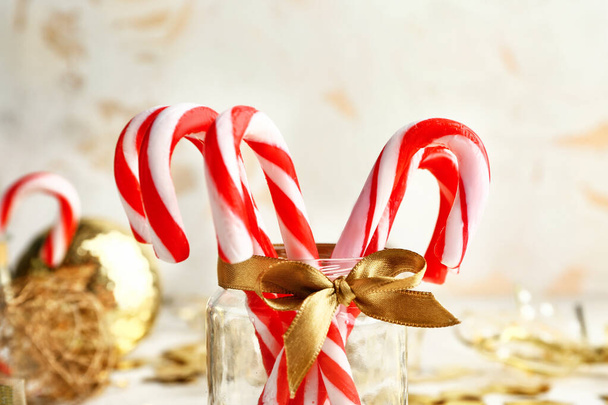 Βάζο γυάλινο με χριστουγεννιάτικα ζαχαρωτά και διακόσμηση στο τραπέζι - Φωτογραφία, εικόνα