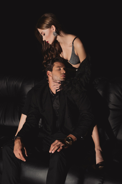 high angle view of attractive woman hugging handsome man isolated on black - 写真・画像