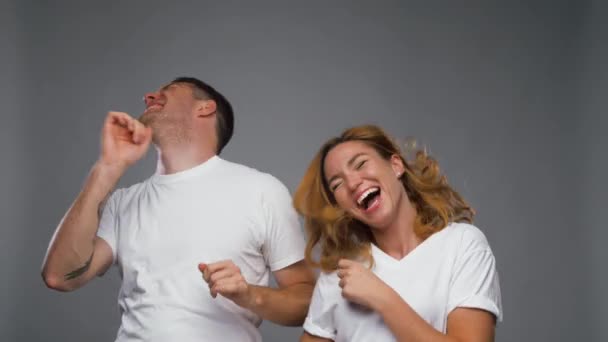 happy couple dancing over grey background - Video, Çekim