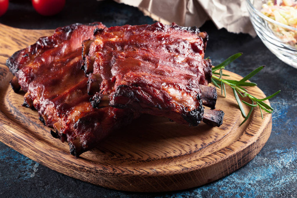 Spicy barbecued pork ribs served with BBQ sauce - Fotografie, Obrázek