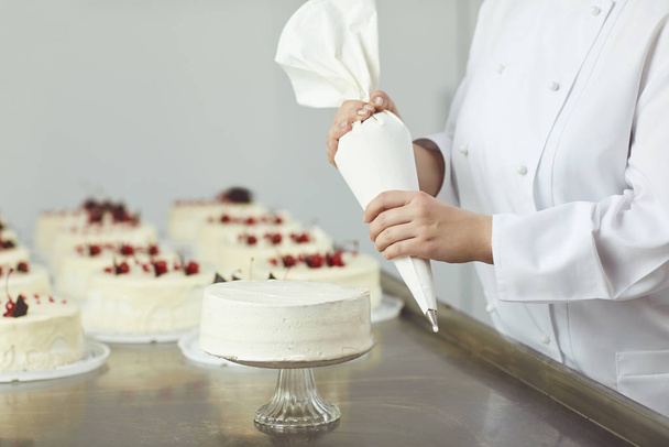 Bag cream for cake.The hands of the pastry chef holding a bag of cream - Foto, imagen