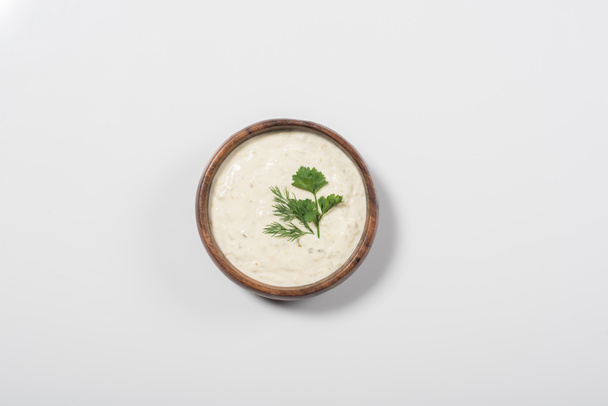 Top view of homemade tzatziki sauce in wooden bowl on white background - Photo, Image