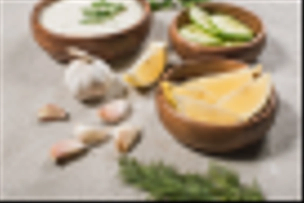 Seçici limon odağı, sarımsaklı salatalık ve taş yüzeyinde tzatziki sosu. - Fotoğraf, Görsel