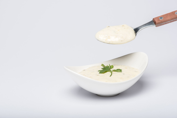 Σπιτική σάλτσα τζατζίκι με κουτάλι σε λευκό φόντο - Φωτογραφία, εικόνα