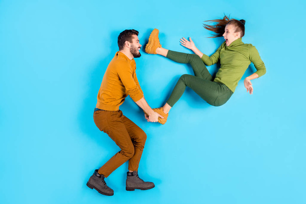 Profile side top above high angle view full length body size photo of cheerful positive beautiful spouses with man throwing his girl away playing waiting for her to fall isolated pastel blue color - Foto, imagen