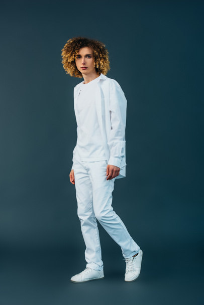 full length view of curly teenager in total white outfit on green - Fotoğraf, Görsel