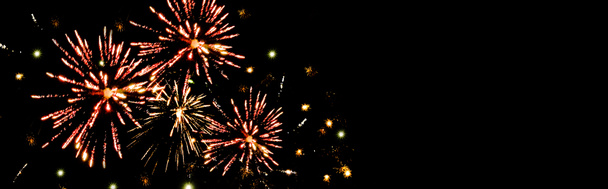 panoramic shot of red festive fireworks in dark night sky, isolated on black - Photo, Image